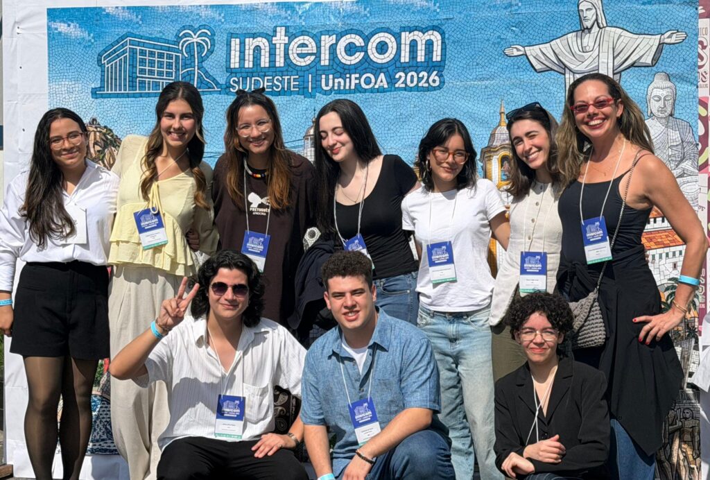 Finalistas com a professora de jornalismo Claudia Bredarioli. Foto Divulgação.